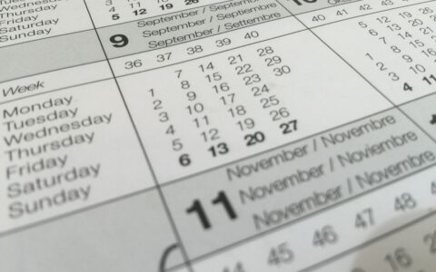Detailed close-up of a calendar displaying months in several languages.