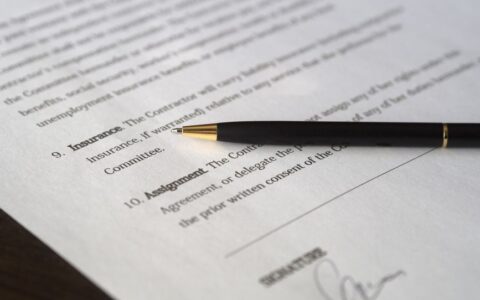 Close-up image of a business contract and pen, signed and ready for agreement.